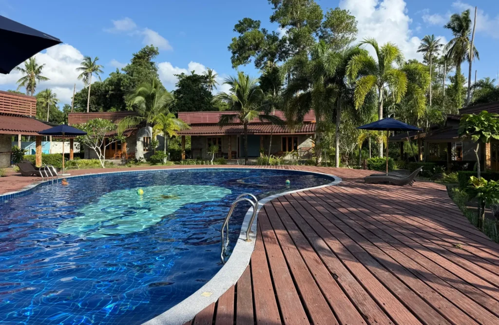 seafar-resort Piscina exterior rodeada de palmeras y bungalós en un resort de Koh Kood